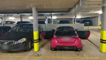 underground parking lot with multiple cars parked, yellow and white markings, yellow and black poles