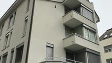 4 story building, white exterior, multiple balconies, windows with shutters