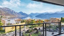 View of mountains, lake, trees and buildings from balcony
