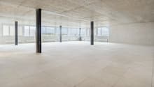 large room, white tile flooring, concrete ceiling, exposed beams, large windows