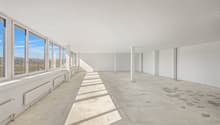 Empty room with large windows, tile flooring, white walls, white ceiling, pillars