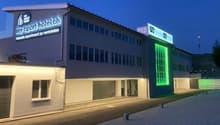 Hotel with multiple floors, modern architecture, garage, and illuminated signage