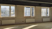 empty room, white walls, three windows, radiators, concrete floor