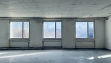 empty room with large windows, white walls, concrete floor, three windows, baseboard heating
