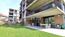 Appartement moderne avec terrasse et espace vert privé.