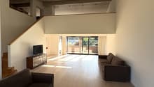 spacious room, wooden floors, modern furniture, large windows, living room setting, staircase