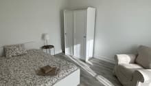 bedroom with bed, nightstand, wardrobe, couch, lamp