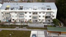 modern apartment building, balcony on every floor, multiple parking spots, green roof