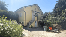 Single story house, yellow painted exterior, garage attached, brick flooring in driveway