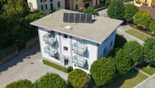3 story house, white exterior, solar panels on roof, balconies on each floor