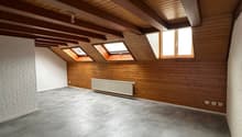 empty room, wooden ceiling, wooden walls, gray tiles, three windows, white radiator