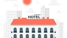 4-story hotel building with arched windows, red roof, and parking spaces in front