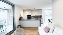 Open-plan living and kitchen area with modern decor and large windows