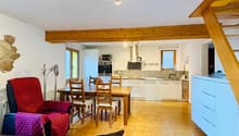 open plan living room and kitchen, wooden floor, dining table, chairs, sofa, radiator, wooden beams, kitchen with microwave, oven, sink, cabinets