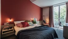 twin bed, bedside table, red wall, balcony, window, curtains