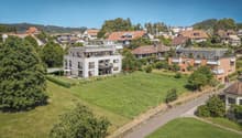 Multiple residential houses in a hilly neighborhood, large front and back yards, some with balconies, greenery and wide roads