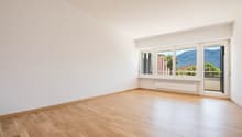 empty room, wooden floor, white walls, large windows with balcony, mountain view