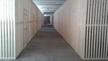 Concrete floor, white and light brown wooden walls, overhead lights