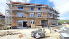 under construction, brick wall, glass windows, metal scaffolding, open doors, construction materials