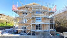 House under construction, brick walls, glass windows, scaffolding, multiple floors