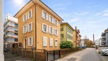 3 story house, yellow exterior, white shutters, wooden fence, street view