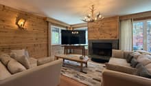 Coin salon avec cheminée et TV / Lounge area with fireplace and TV / Area salotto con camino e TV