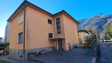 3-story house, beige exterior, double windows, carport, gravel driveway, car parked
