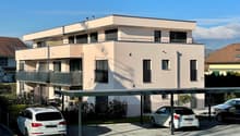 Three story house, white exterior, metal balcony, covered parking, two cars in carport, two cars in street