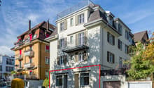 4 story building, cream exterior, red line marks out ground floor apartment for sale