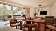 Spacious living room with large windows overlooking a balcony and outdoor greenery. The room features a wooden dining table with circular seating, a comfortable sofa, and a modern chandelier lighting fixture. The overall decor has a warm, natural aestheti