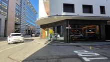 Modern building with glass windows, balcony, and a shopfront with a glass door and windows