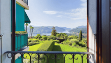 balcony with railings, view of a lake and mountains