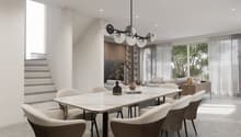 Spacious dining area with a large marble-top dining table and comfortable upholstered chairs. The room features a modern chandelier with glass globes, built-in shelving, and large windows overlooking a balcony or terrace area.