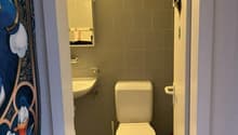 Small bathroom, tiled walls, white sink, white toilet, mirror