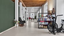 Open space with large wooden beams, white walls, white floor, green wall, living room items