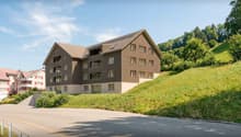 3 story house, brown exterior, multiple windows, balconies, located on a hill