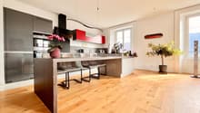 modern kitchen, large island, oak floor, stainless steel appliances, red cabinets, double oven, microwave, dishwasher, island stools