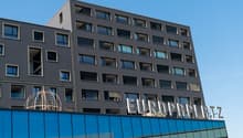 Modern office building with multiple windows, glass facade, signboard reading EUROPLATZ.