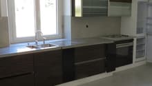 Kitchen with a sink, faucet, oven, and refrigerator under the window.