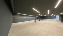 empty parking room, gray walls, white floor, fluorescent lights