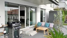 BBQ grill, wooden sofa, table, potted plants, tiles floor