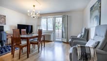 dining room with a table and chairs, a television, a chandelier, and a balcony