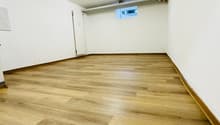 empty room, hardwood floors, white walls, small window on the back wall, a door on the left side