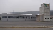 large industrial building, tower, open space, large windows, cloudy sky
