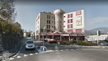 commercial building, large glass windows, ground level, signage, parking area