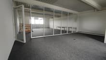 empty room, glass walls, gray floor, white walls, open door, small table, wooden shelf