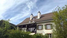 2 story house, brown roof, white walls, green shutters, 2 chimneys, balcony