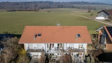 2 story house, red roof, surrounded by fields, distant mountains