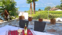 Stone floor, garden table, chairs, scenic view of mountains and lake