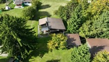 detached house with brown roof, large yard, surrounded by trees, patio